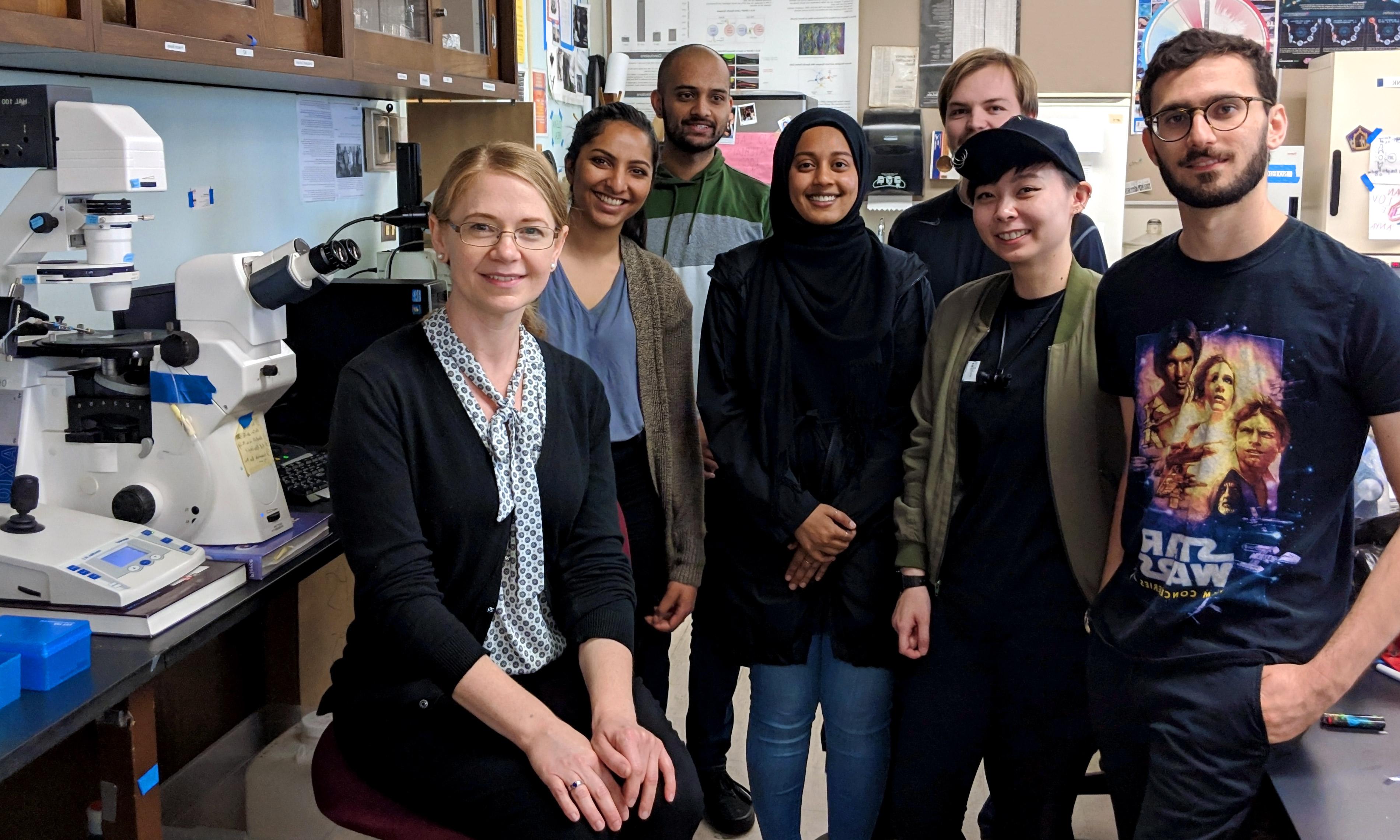 a group of students and their professor in an sjsu biology lab