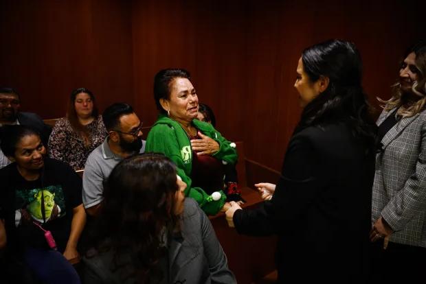 Adriana Vazquez-Chavez, a student assistant with the Record Clearance Project, holds hands before embracing Carmen Navarro, whose son was cleared of past convictions, at Family Justice Center in San Jose. (Shae Hammond/Bay Area News Group)