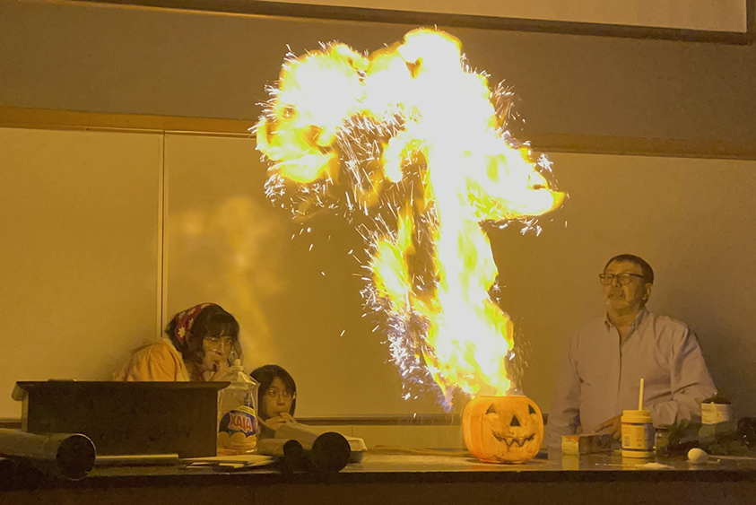 Photograph of Alejandro Garcia and students with a fireball of corn starch.